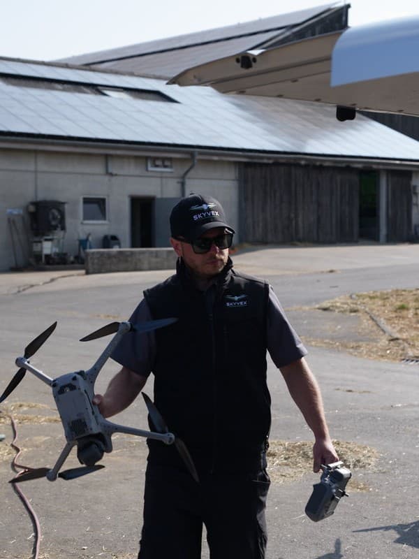 Drohnenpilot von Skyvex trägt Drohne und Fernsteuerung zum nächsten Einsatz